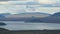 Beautiful tranquil lake and huge snow-capped mountain in horizon, picturesque clouds