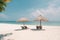 Beautiful tranquil white sand beach with two beach chair and thatched umbrella near palm