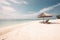 Beautiful tranquil white sand beach with two beach chair and thatched umbrella near palm