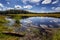 A beautiful transparent forest lake with a bright blue sky reflecting in it