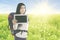 Beautiful traveler with tablet in the blossom meadow