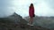 Beautiful traveler woman in a pink sweater stands on the edge of a cliff and enjoys the view of the Masca Valley on the