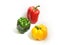 Beautiful triangular composition of fresh bell peppers in bright green, red and yellow colors on a white background with lighting