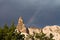 Beautiful troglodyte rising up in stormy sky with rainbow
