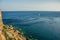 Beautiful tropic panorama of small yacht on vivid blue water sea surface background near rocks shore line landscape view from