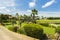 Beautiful tropical nature landscape view. Green palm trees, green plants and grass on blue sky with rare white clouds backgrounds