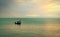 Beautiful tropical sea in the morning with golden sunrise sky. Fisherman in long tail boat with folk fishing culture. Peaceful and