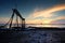 Beautiful tropical sunset background, wooden water pump tower on the muddy beach. cloudy and yellow sky