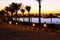 Beautiful tropical sunset at the bay with palms, starlights and calm water.