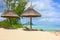 Beautiful tropical white sandy beach with exotic tropical plants,beach umbrellas and sunbeds on traditional mauritian style with a
