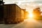 Beautiful truck tractor with a semitrailer transports cargo against the backdrop of a sunset in the evening and a beautiful sky