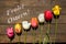Beautiful tulips on a brown wooden table and german words Happy