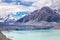 Beautiful turqouise Tasman Glacier Lake and Rocky Mountains in the clouds
