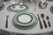 Beautiful turquoise blue white plates with gold on the tablecloth. Festive table setting deep and flat plates knife fork spoons.