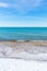 Beautiful turquoise colored water along Lake Michigan shoreline in winter - vertical