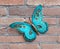 Beautiful turquoise decorative butterfly on a brick wall background