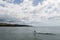 A beautiful Turtle Bay vista on Oahu, with a female longboard surfer in the foreground