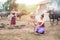 Beautiful two Asian women dressed in Traditional costume with buffalo at farmland,one sit on ground floor open firewood and one