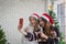 Beautiful two women with santa hat singing karaoke and selfie shooting with smartphone in christmas party