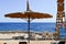 Beautiful umbrella in the form of a hat in the form of a hat and a rescue tower against the backdrop of sun loungers, a blue salt