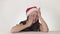 Beautiful unhappy girl teenager in a Santa Claus hat emotionally desperately cries on white background stock footage