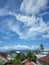 Beautiful and unique clouds in the blue sky above the residential roofs