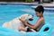 Beautiful unique golden retriever labrador dog and boy relaxing at the pool in a floating bed, dog super funny.