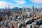 Beautiful urban skyline of Tokyo City under blue sunny sky, with Tokyo Tower standing tall among crowded high-rise skyscrapers