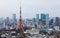 Beautiful urban skyline of Tokyo City under blue sunny sky, with Tokyo Tower standing tall among crowded high-rise skyscrapers