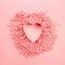 Beautiful valentines day background with baked mold heart-shaped and coral pink confectionery hearts on pink monochrome paper,