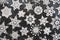 Beautiful varied white cotton crocheted stars and snowflakes on dark background.