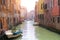 Beautiful Venice canal in early morning light. Old narrow canal with parked boats, Venice, Italy. Picturesque cityscape of Venice