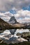 Beautiful vertical shot of a lake surrounded by mountains with a reflection of a person in the water