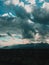 Beautiful vertical shot of a rainy heavy cloudscape over a mountain range