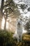 Beautiful vertical shot of a white dog sitting in a park on a sunny day