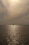 Beautiful vertical split at the horizon contrasty panorama day shot of small lonely boats in calm ocean under soft cloudy sky and