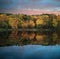 Beautiful vibrant Autumn woodland reflecions in calm lake waters