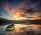 Beautiful vibrant blue and pink Winter sky with single boat floating on ocean