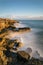 Beautiful vibrant sunset landscape image of Portland Bill rocks