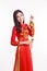 Beautiful Vietnamese woman with red ao dai holding lucky new year ornament