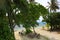 Beautiful view from above on ocean coast. Maldives, Indian Ocean. Empty chairs and tables, no people. Green trees around.