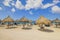 Beautiful view of Atlantic Ocean and people on Eagle Beach with sun loungers and umbrellas.