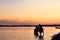 A beautiful view of the beach at sunset, illuminated by the evening sunlight, two riders bathe horses, summer adventures