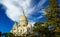 Beautiful view beyond green conifer trees on isolated dome of Sacre Coeur church, clear blue spectacular autumn sky,