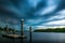 Beautiful view of the blue majestic sky and a lake with a dock and wooden columns