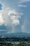 The beautiful view of blue sky with cloud, rain and rainbow over the mountains and buildings of Chiangmai city