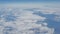 Beautiful view of the blue sky with clouds from the porthole of the plane during the flight