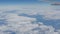 Beautiful view of the blue sky with clouds from the porthole of the plane during the flight