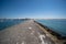 Beautiful view of breakwall and immense rock formations on coastline under clear blue sky