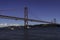 Beautiful view of the Bridge 25th of April over the river Tagus in the heart of Lisbon in Portugal. Small sailing boat and fishing